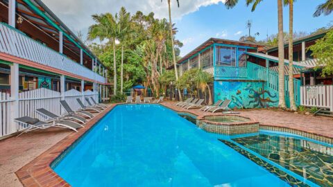 The Arts Factory Lodge pool surrounded by lodges and trees.