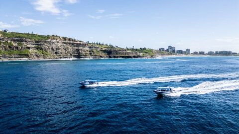 Two CoastXP vessels driving along the rocky coast.