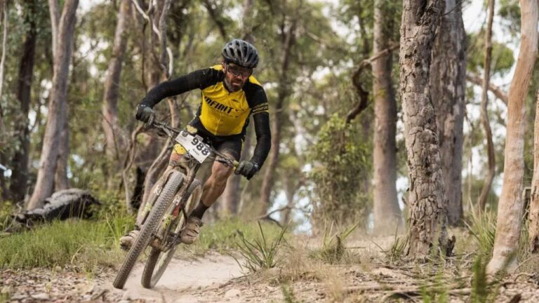 Man riding a mountain bike on a trail in a forest.